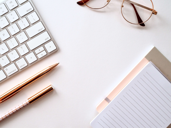 work desk with pen, notebook and glasses